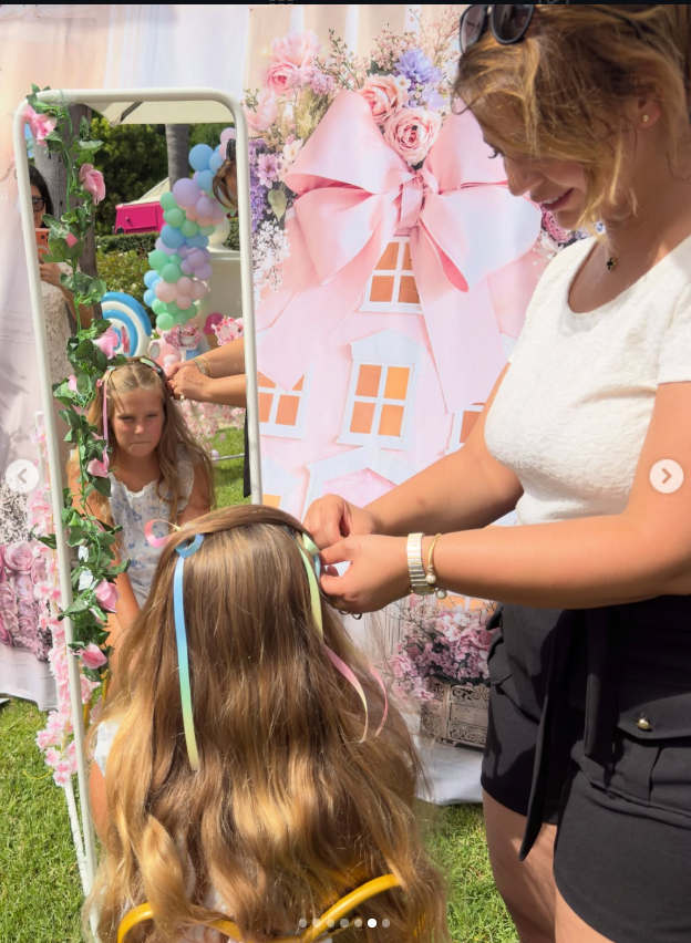 Roza Glam stylist adding ribbons to a girl's hair at a party
